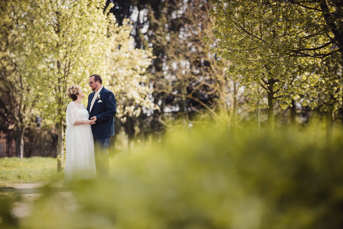 Ehepaar Hochzeit Mann Frau weiß Kleid Umarmung Park grün Shooting 