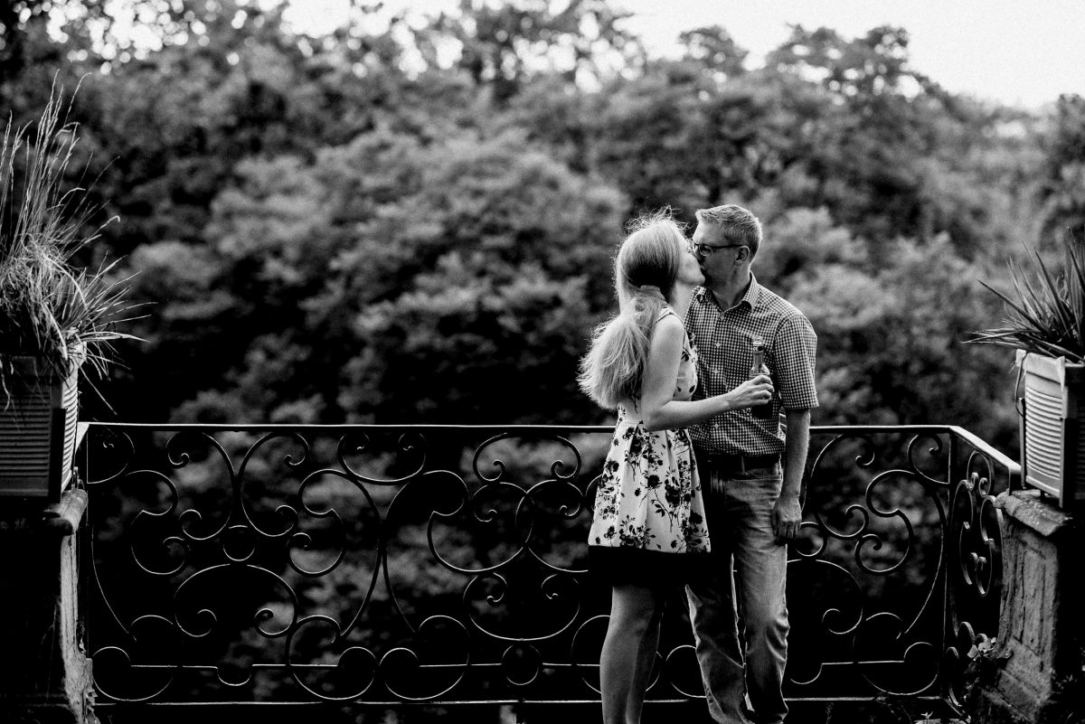 Balkon Eisengeländer Mann Frau Sommerkleid inniger Kuss